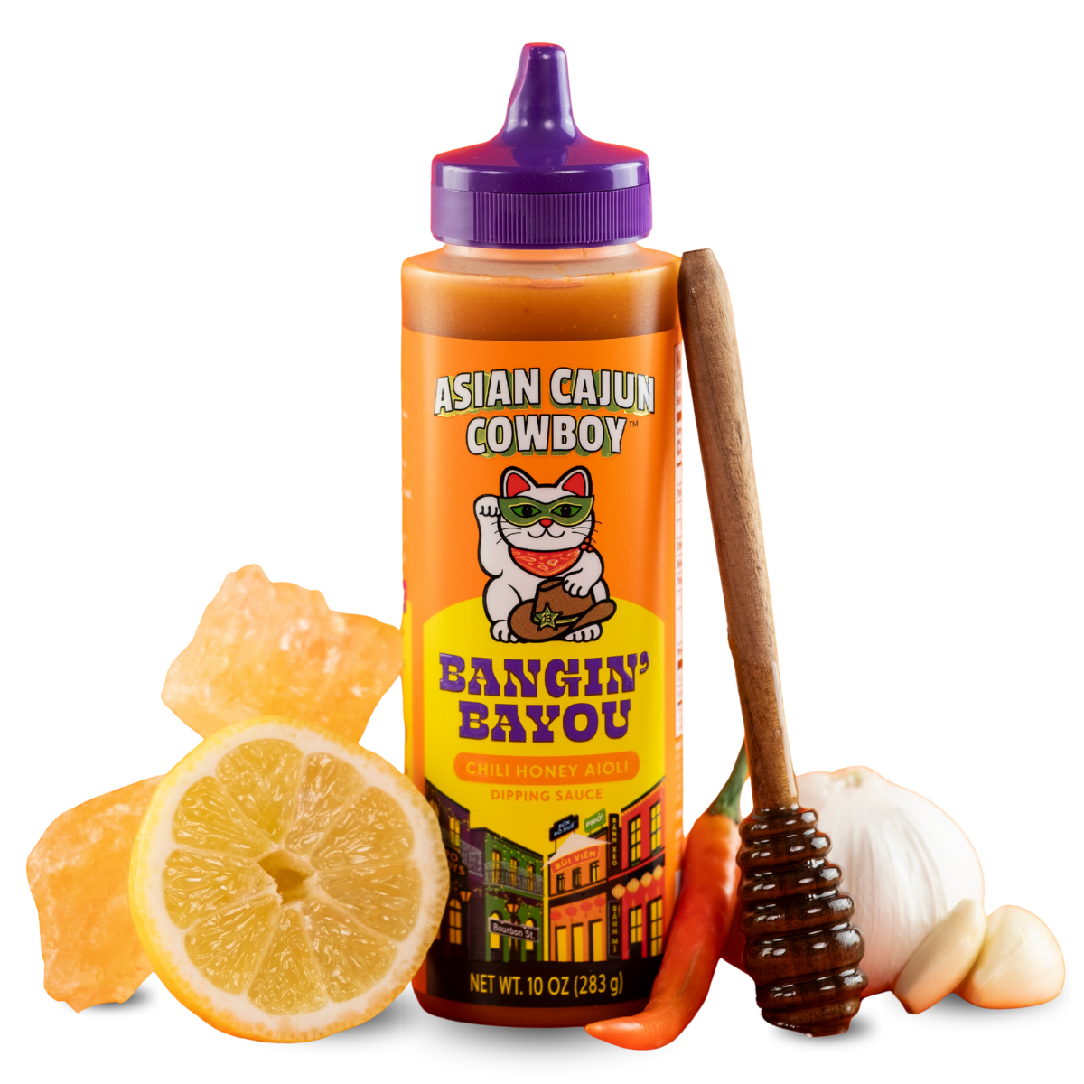 Squeeze bottle of 'Asian Cajun Cowboy' sauce with a spoon, lemon, and garlic on a white background