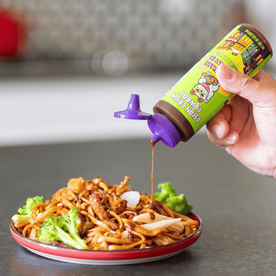 Asian Cajun Cowboy Lemongrass Nuoc Cham Ba dipping sauce being drizzled onto an Asian stir fry.