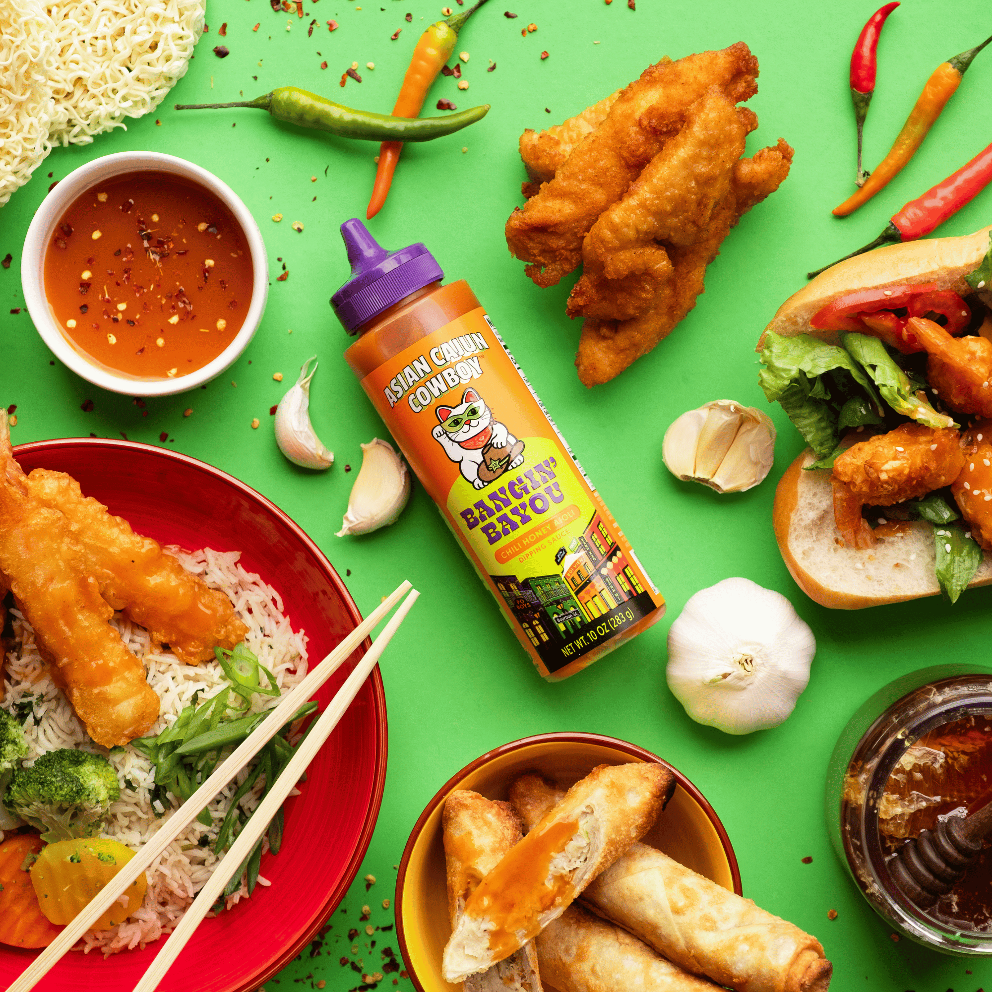 Bangin Bayou bottle surrounded by asian cuisine on a green background.
