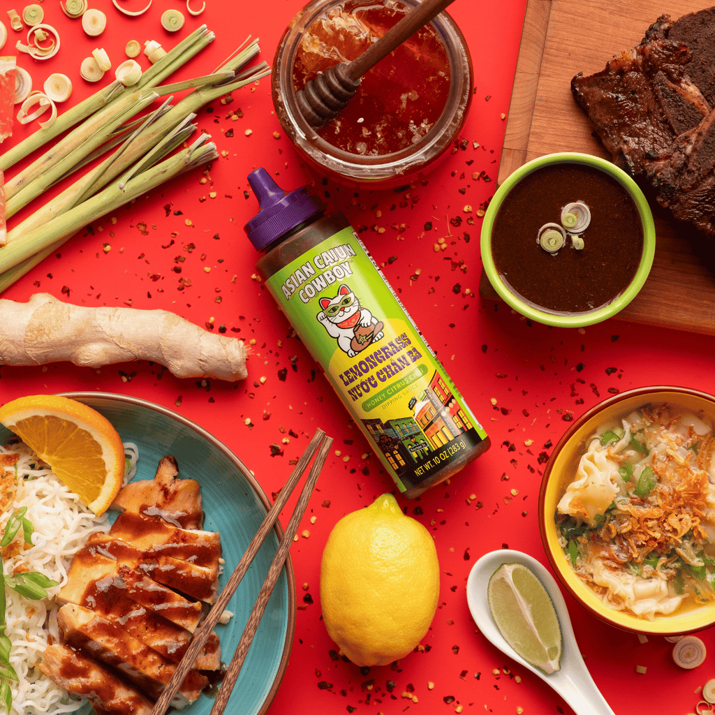 Lemongrass dipping sauce bottle surrounded by Asian cuisine on a red background
