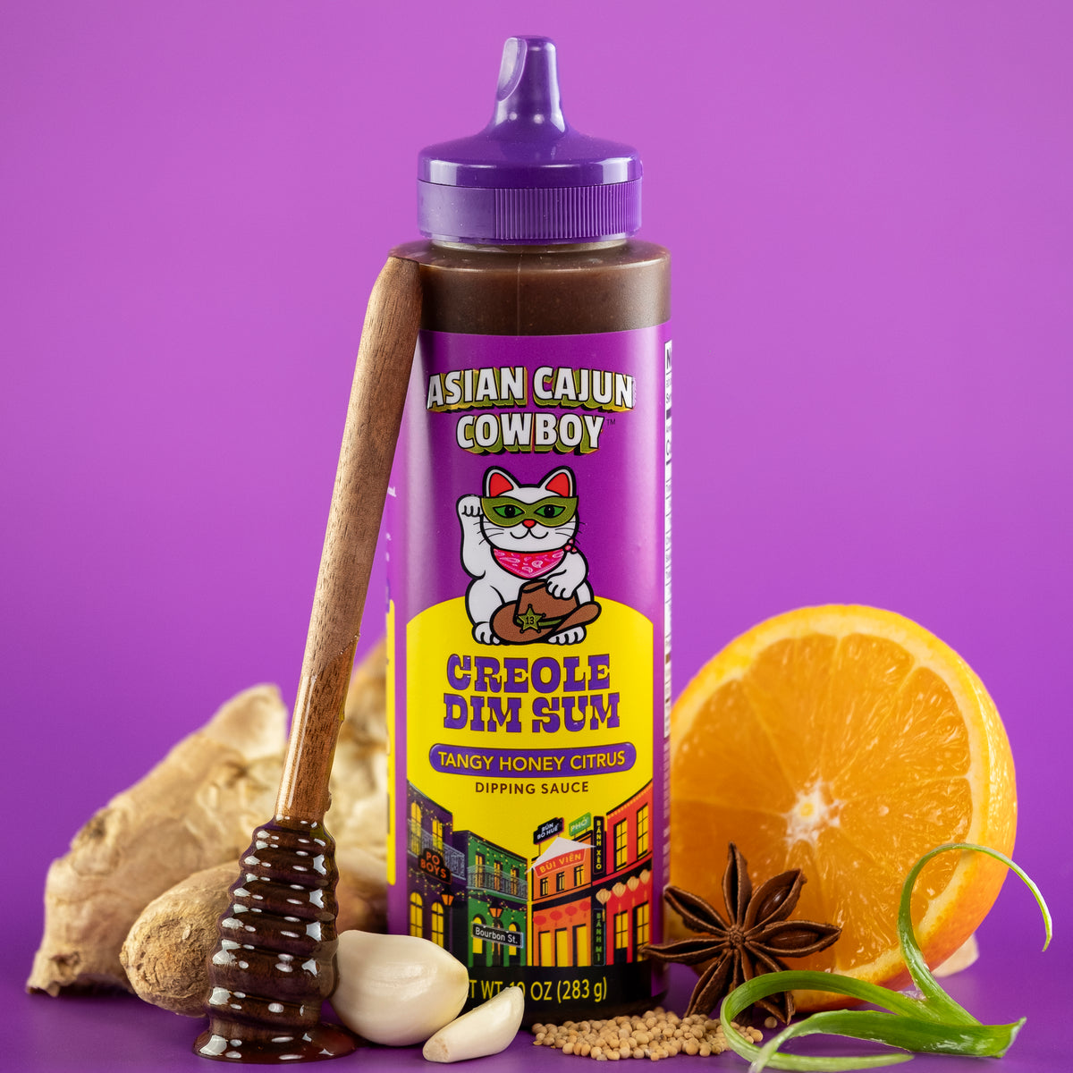 Squeeze bottle of Asian Cajun Cowboy Creole Dim Sum dipping sauce with ingredients on a purple background
